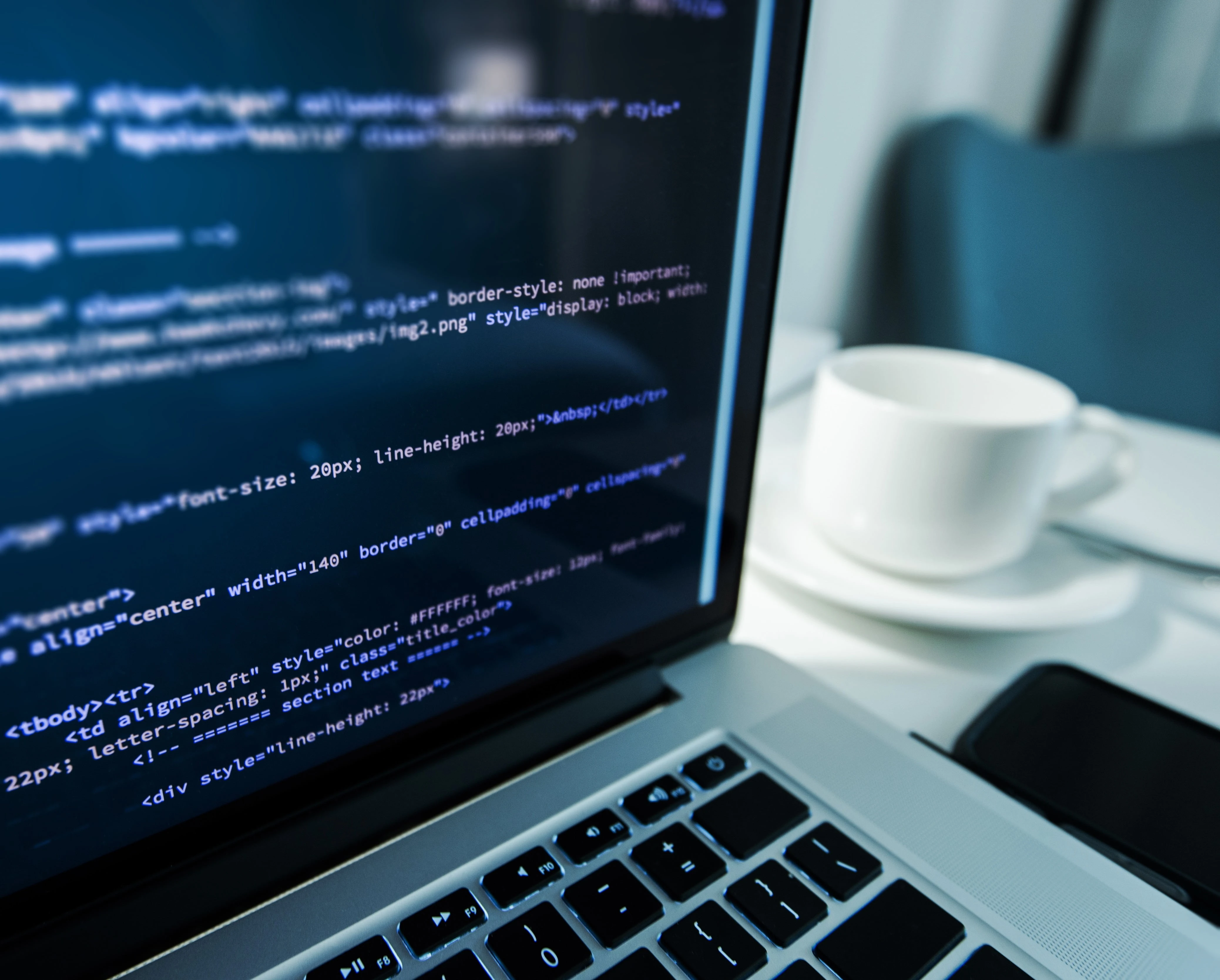 A close-up of a laptop screen displaying HTML and CSS website code